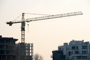 Fototapeta premium Tower cranes and high residential apartment buildings under construction. Real estate development