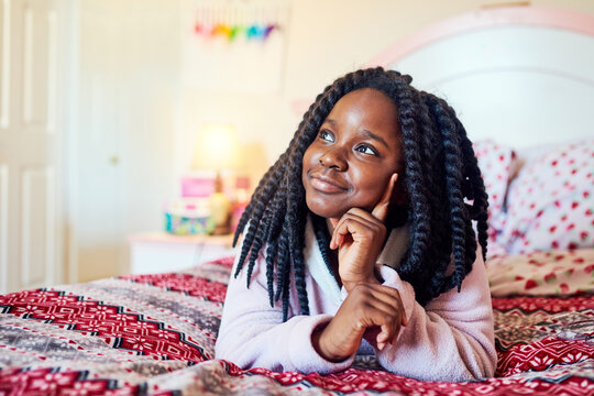 Its morning, thinking about what to do today. Shot of an adorable little girl chilling on her bed in her bedroom.
