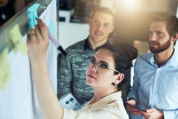 Jotting down their plans. Shot of a group of businesspeople brainstorming in an office.