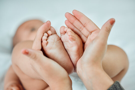The smallest feet leave the biggest footprints on your heart. Closeup shot of a woman holding up her babys tiny feet.