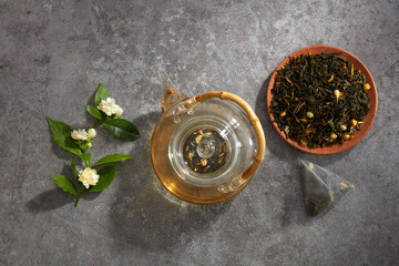 A top view of jasmine tea decorated in wooden dish and cement background