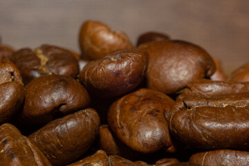MACRO PHOTOGRAPHY OFSTACKED ROASTED COFFEE BEANS WITH WARM LIGHTING AND OUT OF FOCUS BACKGROUND