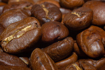 MACRO PHOTOGRAPHY OFSTACKED ROASTED COFFEE BEANS WITH WARM LIGHTING AND OUT OF FOCUS BACKGROUND