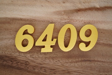 Golden Arabic numerals on a real brown and white wooden floor number 6409