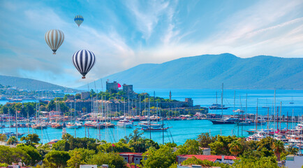 Hot air balloon flying over Saint Peter Castle (Bodrum castle) and marina in Bodrum, Turkey