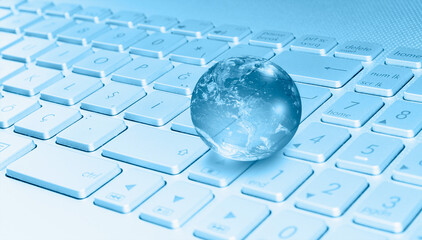 Glass globe on laptop keyboard 