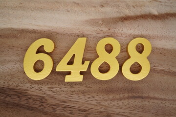 Golden Arabic numerals on a real brown and white wooden floor number 6488