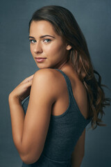 Fototapeta premium Gorgeous and flawless. Studio shot of a beautiful young woman posing against a blue background.