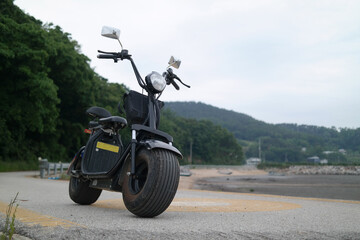 An electric scooter with thick wheels is standing.