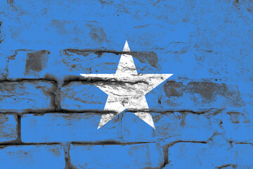 Distressed old somalia flag on a brick structural concrete wall surface