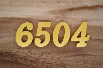 Golden Arabic numerals on a real brown and white wooden floor number 6504