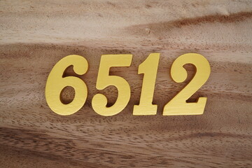 Golden Arabic numerals on a real brown and white wooden floor number 6512