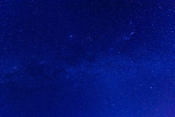 The sky dark blue with many stars and mountain range