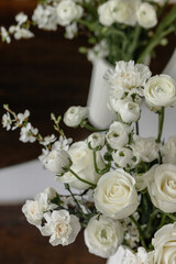 Composition of white flowers in a vase on a chest of drawers