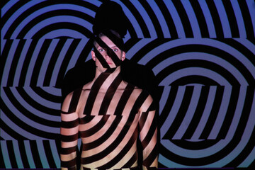 His reality is an illusion. Studio shot of a young man posing against abstract lighting.