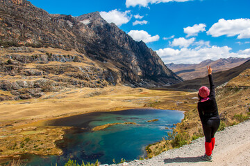 Fototapeta premium Hiker in Mountainous landscape with lagoon and blue sky with clouds in the background.