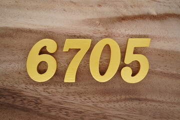 Golden Arabic numerals on a real brown and white wooden floor number 6705