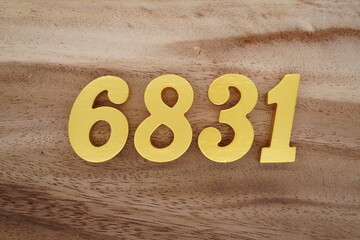 Golden Arabic numerals on a real brown and white wooden floor number 6831