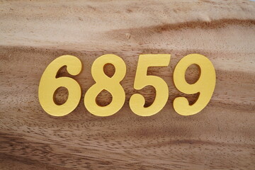 Golden Arabic numerals on a real brown and white wooden floor number 6859