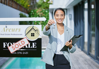 Congratulations, its all yours. Shot of a young female real estate agent holding keys to a new...