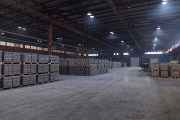 Warehouse of finished products at the enterprise for the production of bricks for construction. Industrial workshop with concrete floor and artificial lighting. 