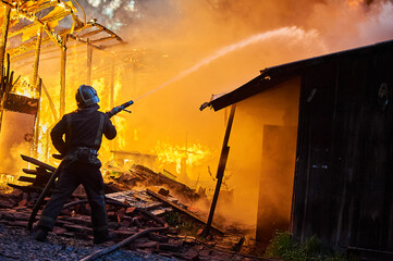 Firefighters extinguish a fire in a farm building
