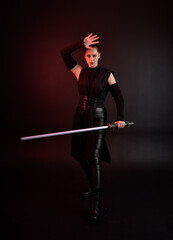 Full length portrait of pretty redhead female model wearing black futuristic scifi leather cloak...