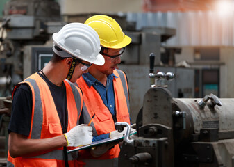 Asian male engineer team monitors and control Planning for maintenance of metalworking machines in industrial plants,