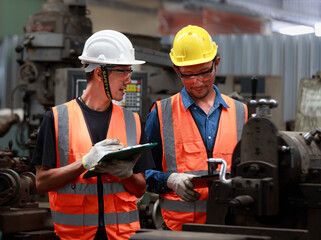Asian male engineer team monitors and control Planning for maintenance of metalworking machines in industrial plants,