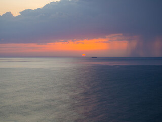 Thunderstorm at sea at dusk. The Beauty of Sunrise waves. Seascape with dramatic cloudy sky and rising sun in Qatar. The view from beach