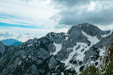 Fototapeta na wymiar Scenic view on rocky sharp cloud covered summit of Jezerska Kocna in Kamnik Savinja Alps in Carinthia, border Austria and Slovenia. Mountain peaks in the Vellacher Kotschna. Mountaineering. Freedom