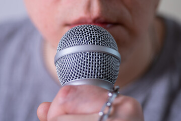 A man speaks into a microphone in close-up.