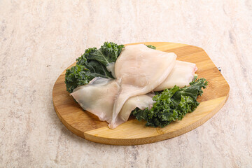 Raw squid over wooden board