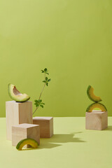 A front view of avocado decorated in wooden podium with green background for advertising 