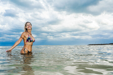 beautiful woman in bikini in the sea playing with water, hermosa mujer en bikini en el mar jugando con el agua
