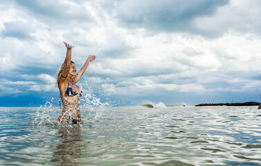 beautiful woman in bikini in the sea playing with water, hermosa mujer en bikini en el mar jugando con el agua