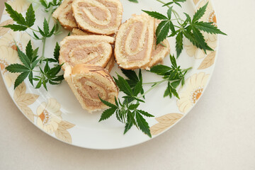 Sweet roll with marijuana oil on white plate. Cannabis kitchen. Layout of delicious dessert, top view close up.