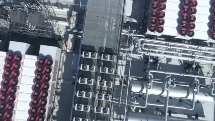 Overhead look down. Datacenter roof with rooftop fans, piping and tanks of HVAC aircon cooling system.