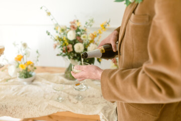 hands of groom pouring champagne