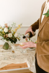 groom pouring champagne into glass