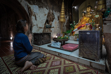 Fototapeta na wymiar Asian Buddhist women pray at the ancient tunnel Temple or Wat U-Mong Temple or the cave temple.