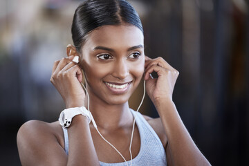 Ready to get started on the best workout today. Shot of a sporty young woman listening to music while exercising in a gym.