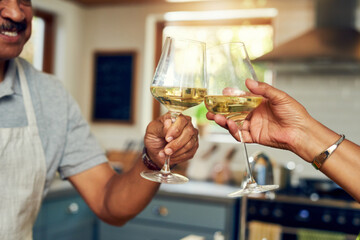 Bon appetit. Cropped shot of a mature couple toasting with wine in the kitchen at home.