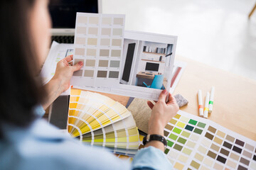 Close up of woman architect working on interior renovation. Designer choosing color samples...