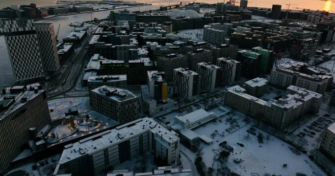 Aerial view of buildings in Jatkasaari, winter sunset in Helsinki - tracking, drone shot