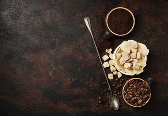 Bowls with dried ginger, brown lump and granulated sugar, coffee beans and ground coffee as...