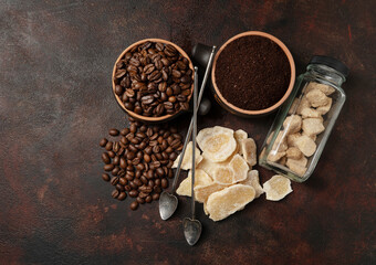 Bowls with dried ginger, brown lump and granulated sugar, coffee beans and ground coffee as...