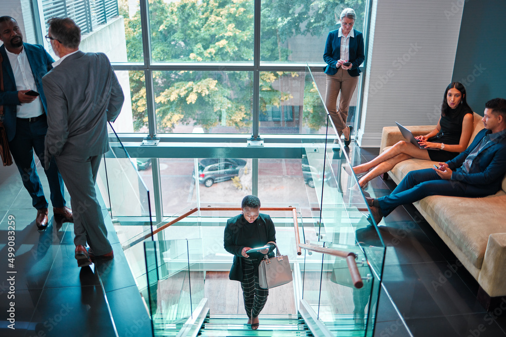 Aufkleber lets get this day started. shot of a young businesswoman walking up the stairs while using a digital