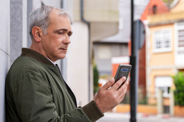 Obraz na płótnie Canvas adult man on the street using smartphone