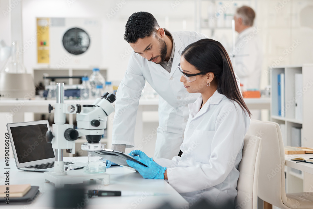 Poster Sharing viewpoints on the days discoveries. Shot of two scientists working together in a lab.